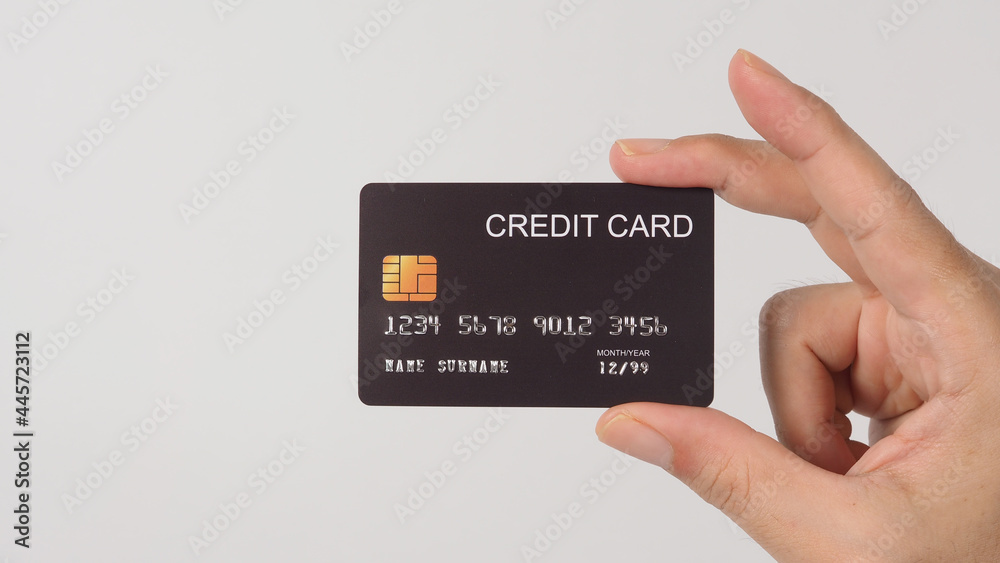 Hand is holding black credit card isolated on white background. Hand is holding black credit card isolated on white background.