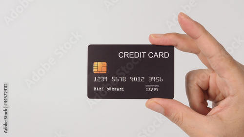 Hand is holding black credit card isolated on white background.