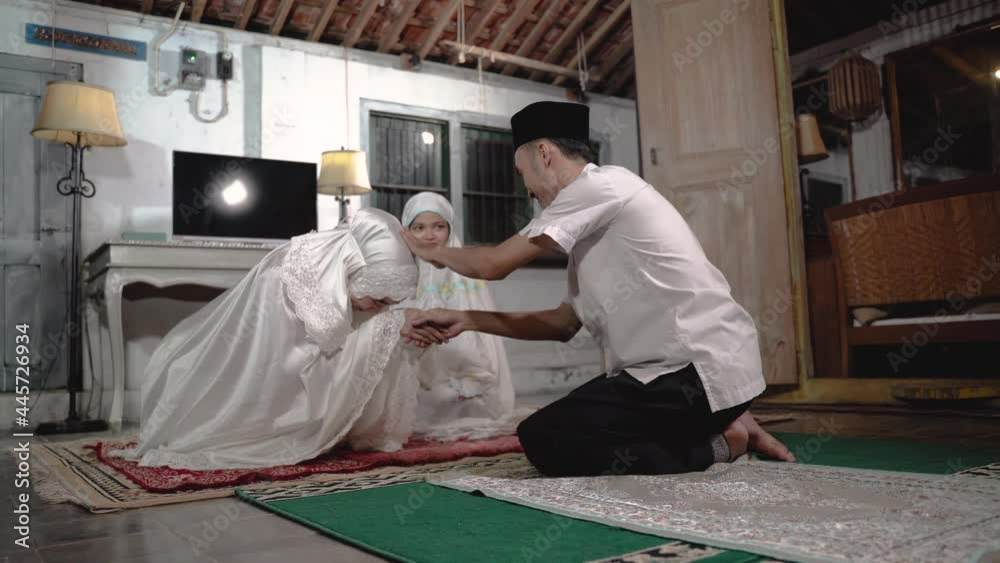 asian muslim family praying jamaah together at home. sholat or salah wearing white and hijab asian muslim family praying jamaah together at home. sholat or salah wearing white and hijab