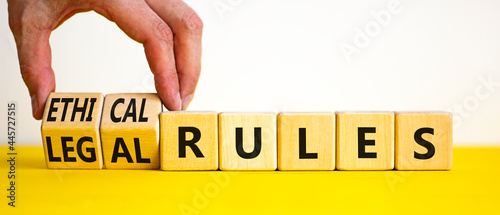 Ethical or legal rules symbol. Businessman turns wooden cubes and changes words 'ethical rules' to 'legal rules' on a beautiful white background. Business, ethical or legal rules concept. Copy space.