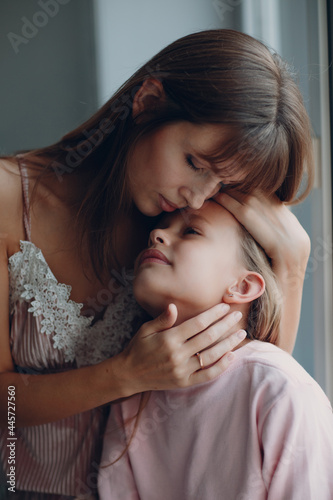 Mother hug little daughter child girl at home. Single parenting and motherhood.