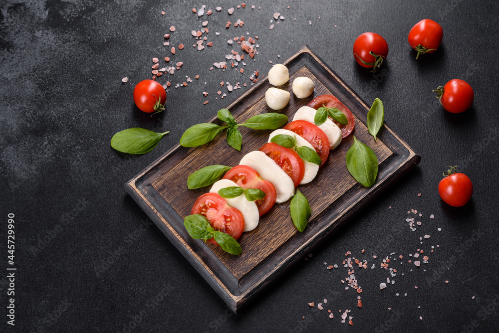 Italian caprese salad with sliced tomatoes, mozzarella cheese, basil, olive oil Italian caprese salad with sliced tomatoes, mozzarella cheese, basil, olive oil