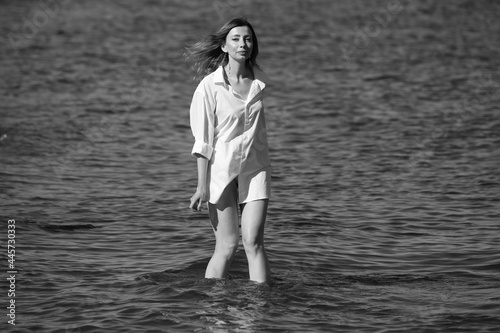 Portrait of a woman in white shirt in the sea in black and white