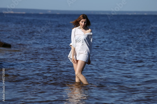 Woman in white shirt standing in the sea