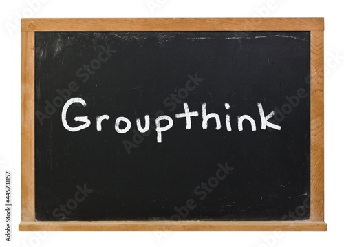 Groupthink written in white chalk on a black chalkboard isolated on white