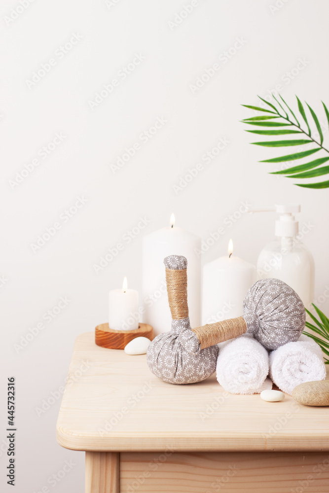Spa treatment with herbal bags and candle on white background. Close up, copy space