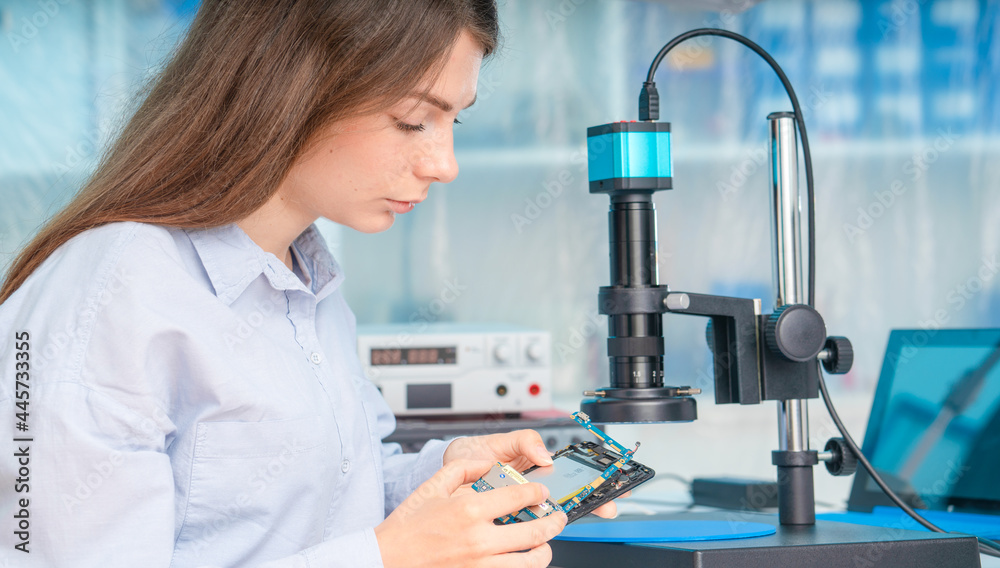 A young woman is experimenting with Lan on Chip devices. Microfluidics device A young woman is experimenting with Lan on Chip devices. Microfluidics device