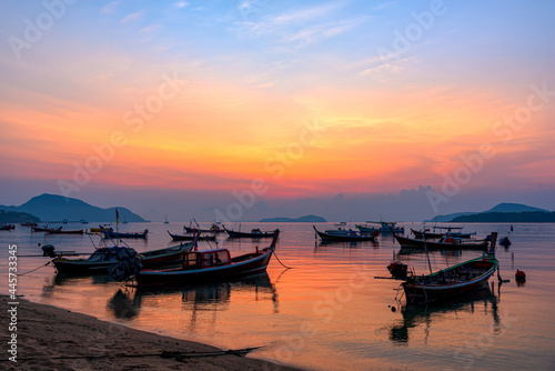 Beautiful sunrise scenery with fishing boats at Rawai Beach in Phuket Island, Thailand.