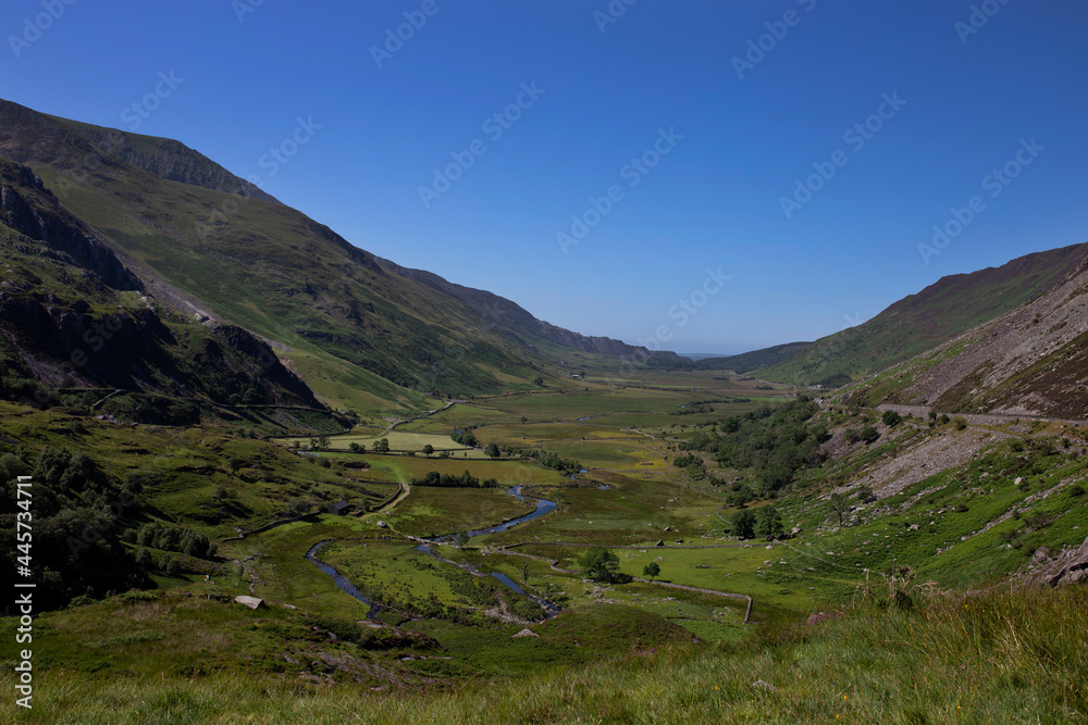 Nant Ffrancon Valley and pass with Afon Ogwen winding through it and the A5 road on the right hand side.  Part of Snowdonia National Park in North Wales