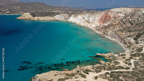 Aerial drone view of iconic volcanic white chalk sandy organised with sun beds and umbrellas beach of Firiplaka with turquoise clear sea and rocky colour formations  Milos island  Cyclades  Greece