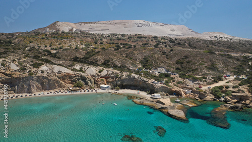 Aerial drone view of iconic volcanic white chalk sandy organised with sun beds and umbrellas beach of Firiplaka with turquoise clear sea and rocky colour formations, Milos island, Cyclades, Greece © aerial-drone