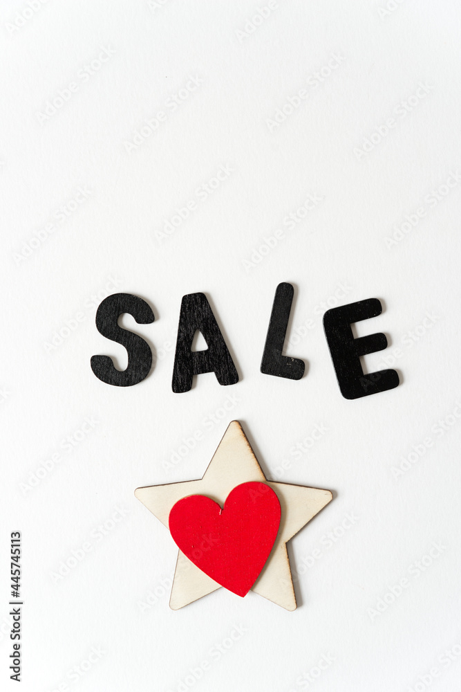 sale sign with untreated wooden star and painted red heart on white