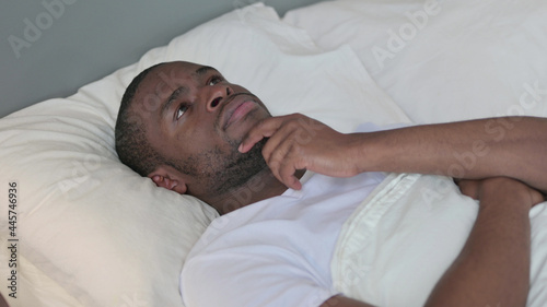 Pensive Young African Man Laying in Bed Thinking 