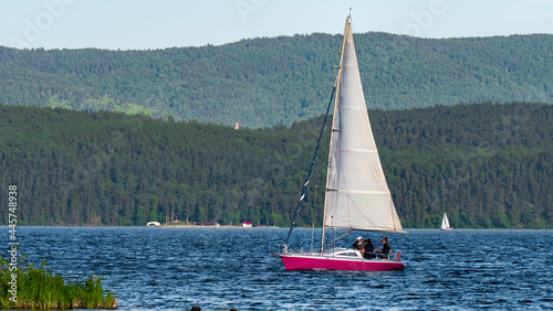Fototapeta Naklejka Na Ścianę i Meble -  a boat with a sail floats in the lake