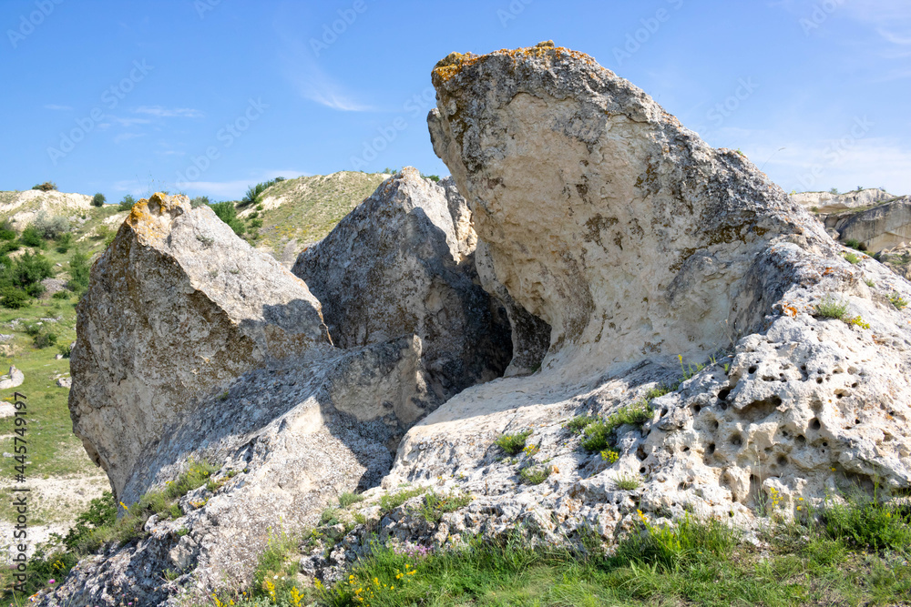 Stone rocks, the texture of a mountain cliff and a beautiful blue sky in the summer season. Traveling on foot