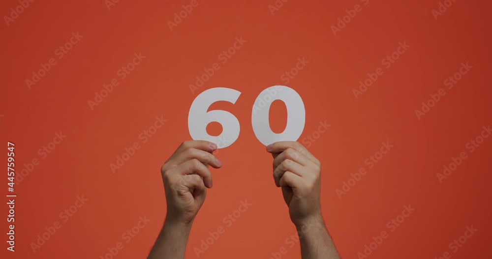 Number sixty in hands. Man showing digits, 60 made of carved paper for voting or mathematics learning Number sixty in hands. Man showing digits, 60 made of carved paper for voting or mathematics learning