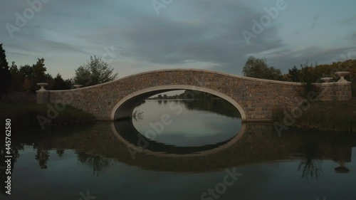 Aeria. The drone flies over a picturesque lake, river. The drone flies under a beautiful bridge.