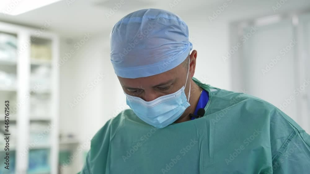Portrait of surgeon in mask during operation. Male doctor in medical uniform performs a plastic surgery in the operating room. Portrait of surgeon in mask during operation. Male doctor in medical uniform performs a plastic surgery in the operating room.