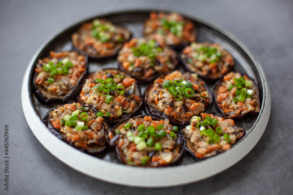 Eggplants baked with vegetables on a black plate Eggplants baked with vegetables on a black plate