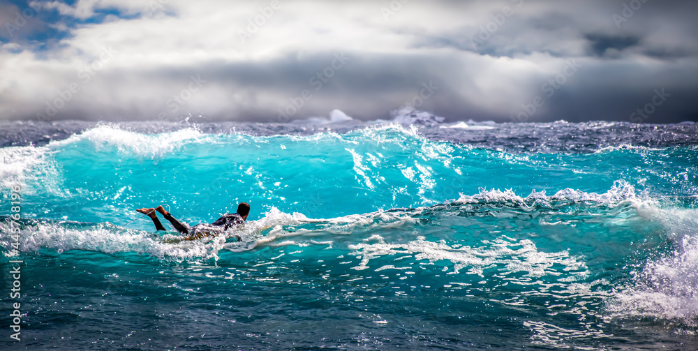 Fototapeta premium A surfer surfing in a rough sea