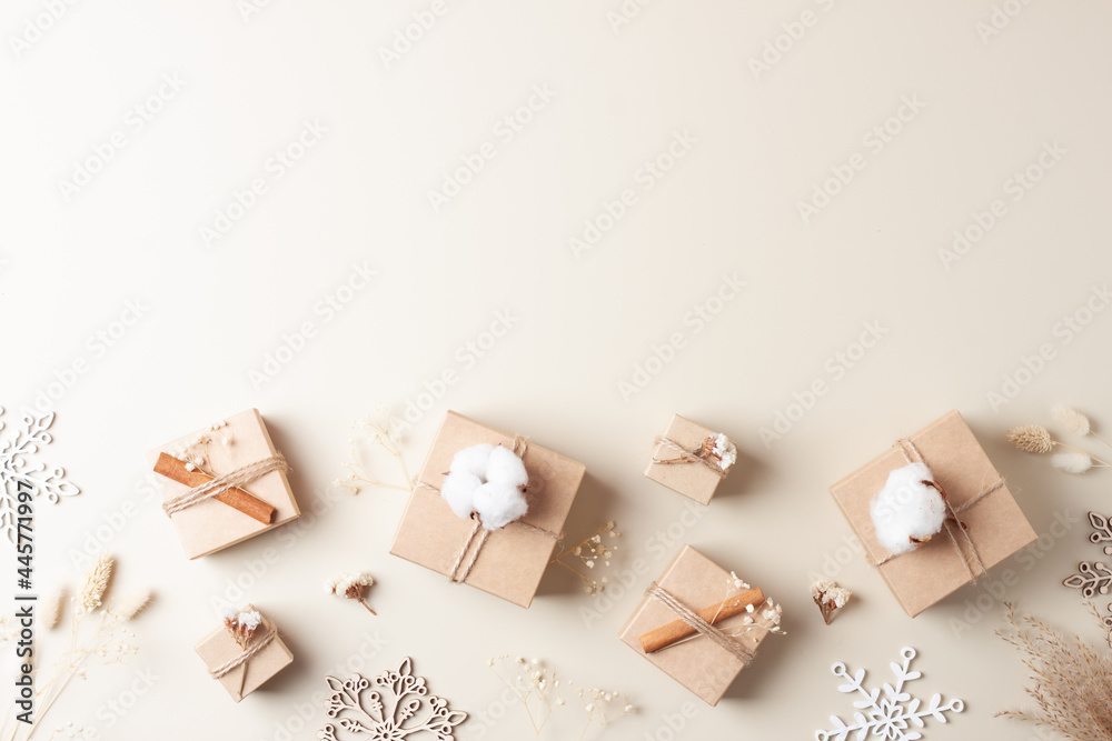 Christmas decorations with packaging gifts in craft paper and flowers on beige background. Zero waste Christmas holiday concept. Flat lay, copy space Christmas decorations with packaging gifts in craft paper and flowers on beige background. Zero waste Christmas holiday concept. Flat lay, copy space