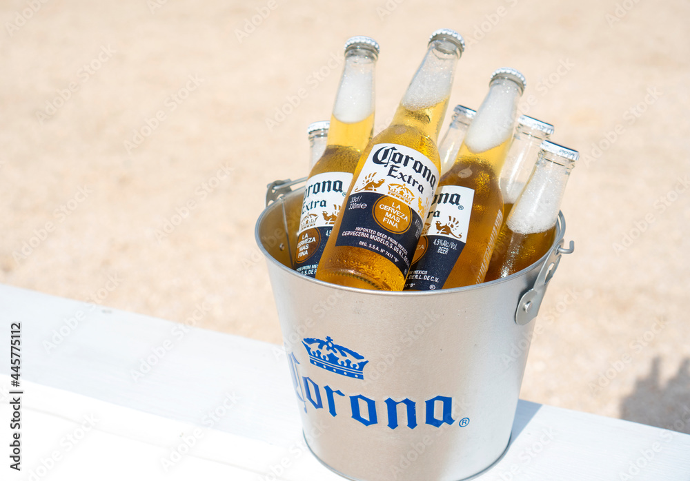 Stockfoto GENICHESK, UKRAINE - 19 June 2021: Illustrative editorial of  chilled Corona beer bottles in a branded bucket on the beach. | Adobe Stock