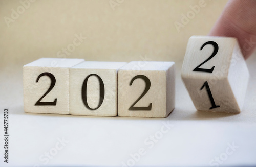Wallpaper Mural The year 2022 written on wooden cubes, finger flipping year to year, New year concept background, starting new natural modern colored design stylish Torontodigital.ca