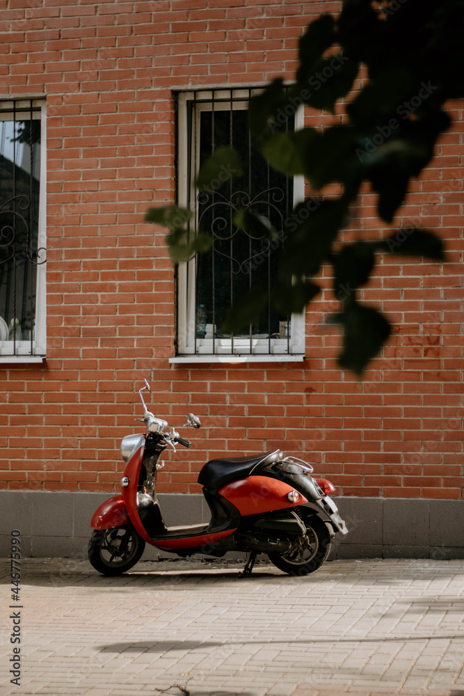 red scooter parked on the street