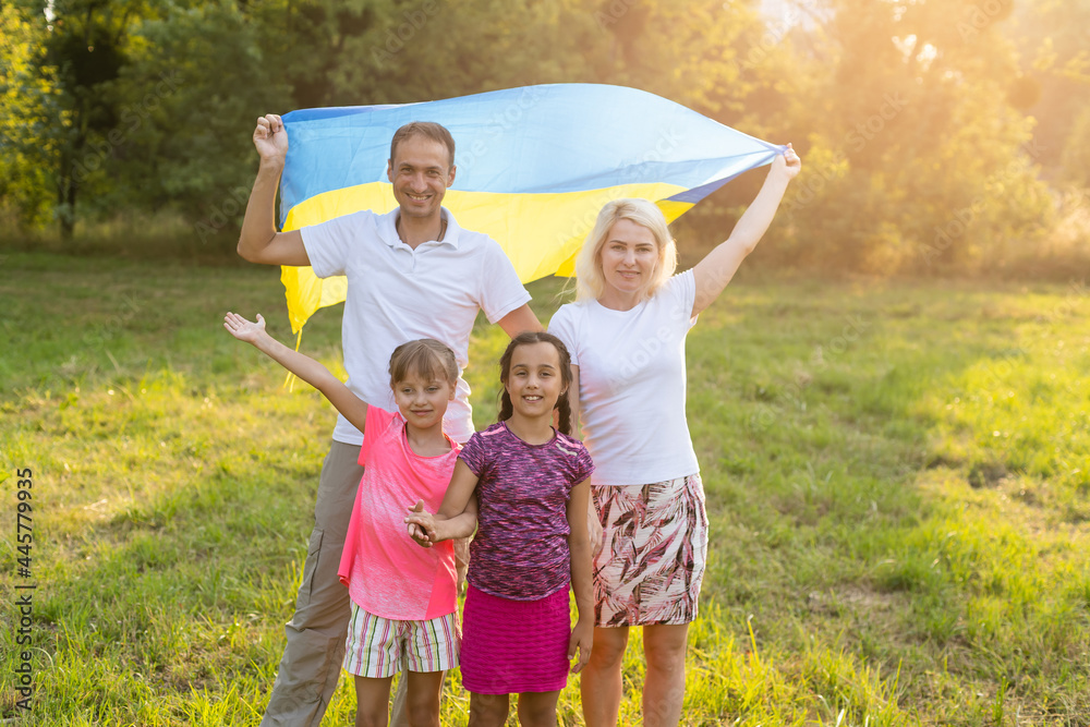 Fototapeta premium happy family with flag of ukraine in field. lifestyle