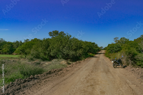 motocicleta al costado de camino de tierra