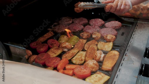 Meat and vegetables are cooked on a grill. Preparation of delicious shish, grilled meat bbq, with tasty vegetables onion, zucchini, outdoor kitchen. Summer, autumn, spring picnic.