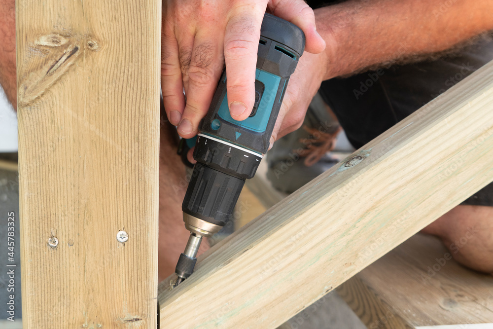 Close up of a carpenter with drilling machine construction tool