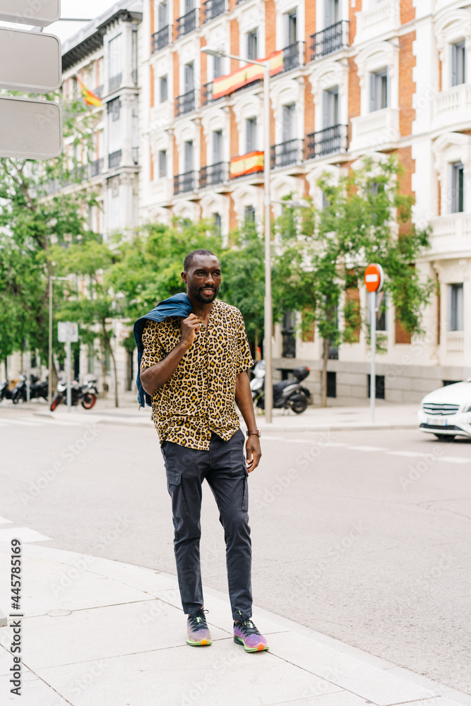 positive afro american stylish man in european city