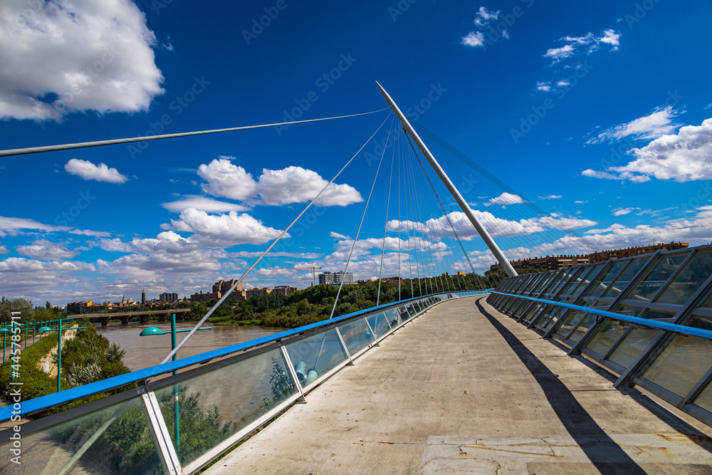 pedestrian suspension bridge over the Ebro river in Zaragoza, Spain on a summer day