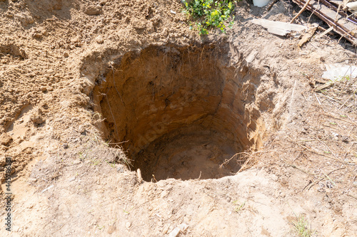 Fotografie, Obraz a deep hole is dug in the ground, a sinkhole in the ground