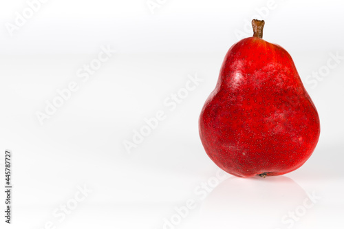 Detailed side view on an isolated, red pear on a white background