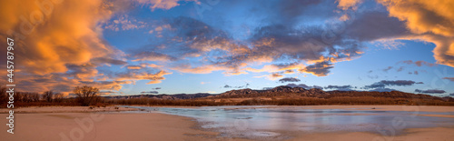 Winter Sunset at Chatfield - A colorful panoramic sunset view of frozen Chatfield Reservoir, with rolling hills of Front Range at horizon. Chatfield State Park, Denver-Littleton, Colorado, USA.