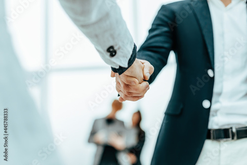 Obraz na płótnie close up. businessman and businesswoman shaking hands with each other w salonie
