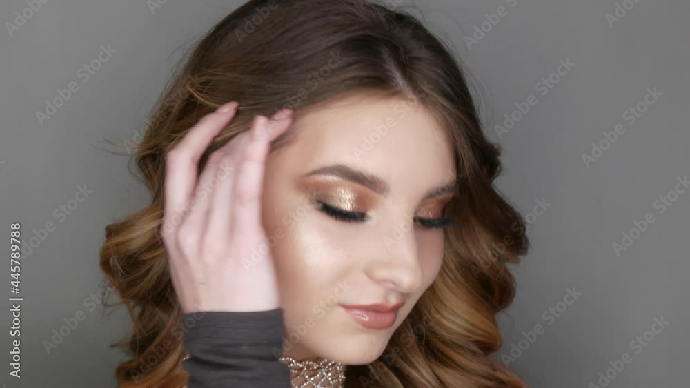 Portrait of beautiful young girl model in stylish evening make up smoky eyes posing. Long eyelash extensions eye makeup in delicate beige tones transparent lip gloss and necklace of rhinestones Portrait of beautiful young girl model in stylish evening make up smoky eyes posing. Long eyelash extensions eye makeup in delicate beige tones transparent lip gloss and necklace of rhinestones