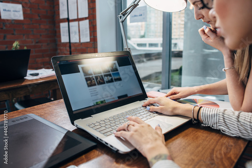 Photography Two women working on new website design choosing pictures using the laptop surfi