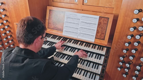 Organist plays music on church organ photo