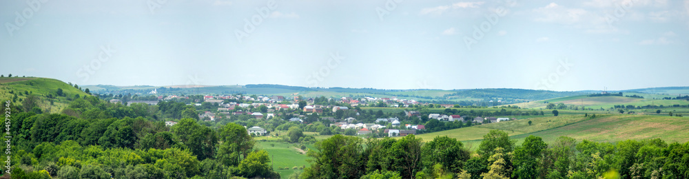 Beautiful summer countryside landscape in Ukraine, forest field and village