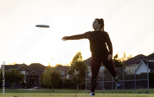 Fotografie White Caucasian Adult Woman Playing Ultimate Frisbee in the Green Field at neighborhood city park