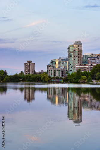 View of Lost Lagoon in famous Stanley Park in a modern city with buildings skyline in background. Colorful Sunset Sky. Downtown Vancouver, British Columbia, Canada. © edb3_16