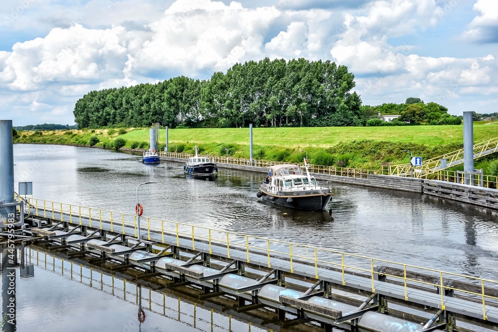 In the beautiful Dutch landscape, pleasure boats pass through Sluis Engelen or the “Henriëttesluis”, close to the river Maas. Netherlands, Holland, Europe In the beautiful Dutch landscape, pleasure boats pass through Sluis Engelen or the “Henriëttesluis”, close to the river Maas. Netherlands, Holland, Europe