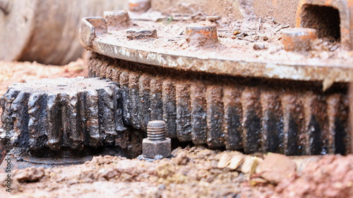 Old main drive cogs. Chipped and dirty rusted cogs for hydraulic heavy equipment crane drives with copy space. Selective focus photo