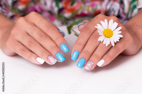 Female hands with summer manicure nails  decorated with camomile flowers