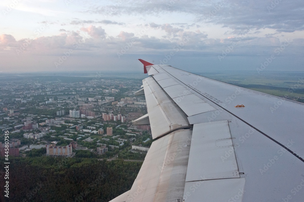 The city is visible under the wing of the plane
