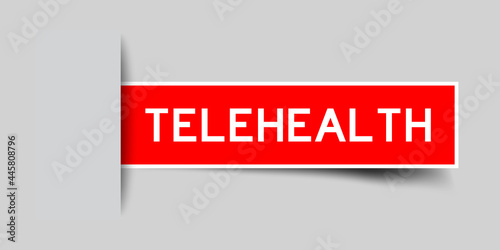 Label sticker red color in word telehelth that inserted in gray background photo