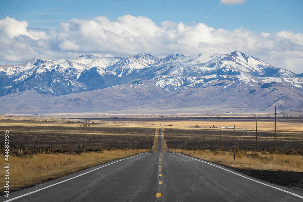 A long, straight road heading into the distant mountains in Idaho.